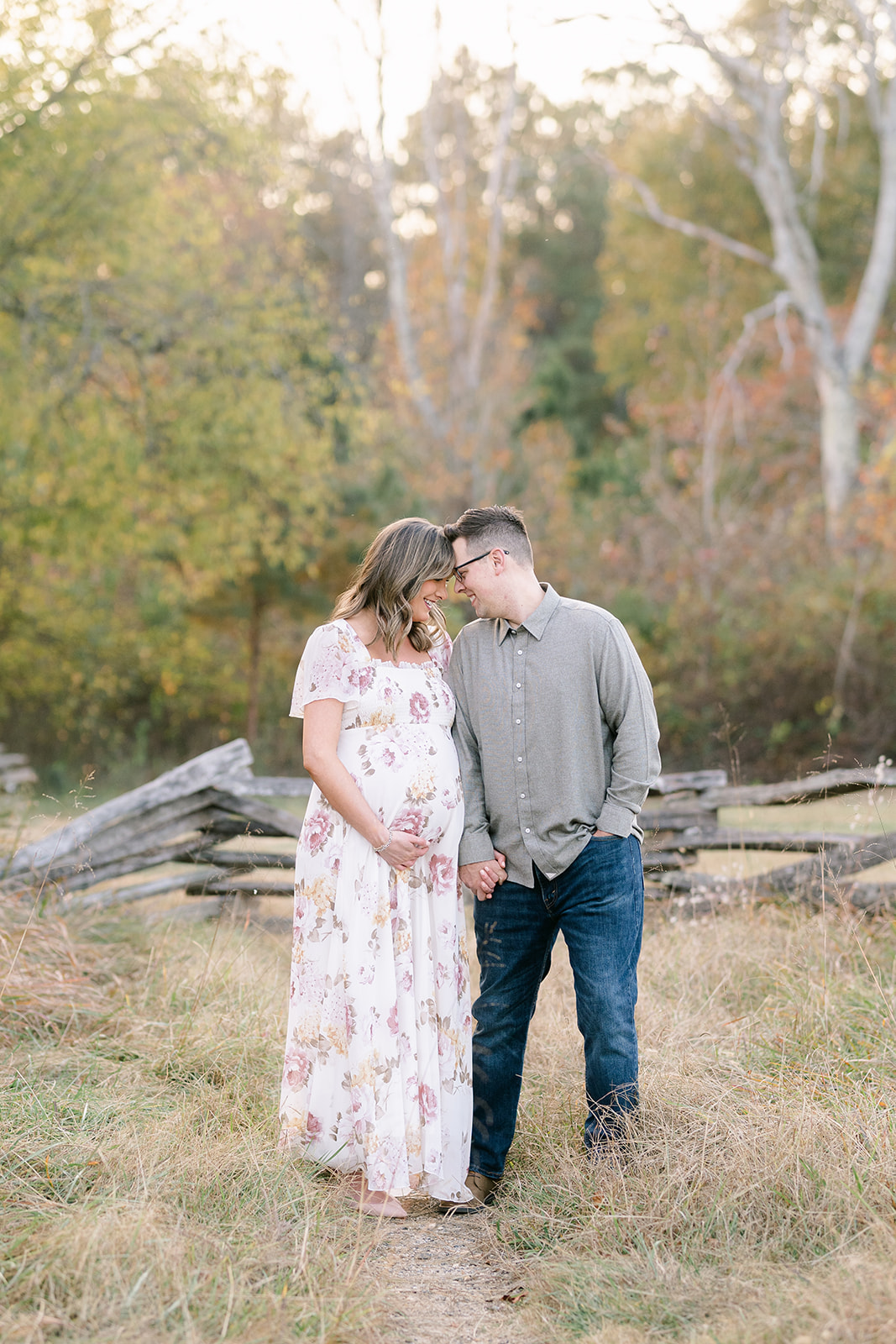couple in field looking at each other for session with Marietta Maternity Photographer Lindsey Powell Photography