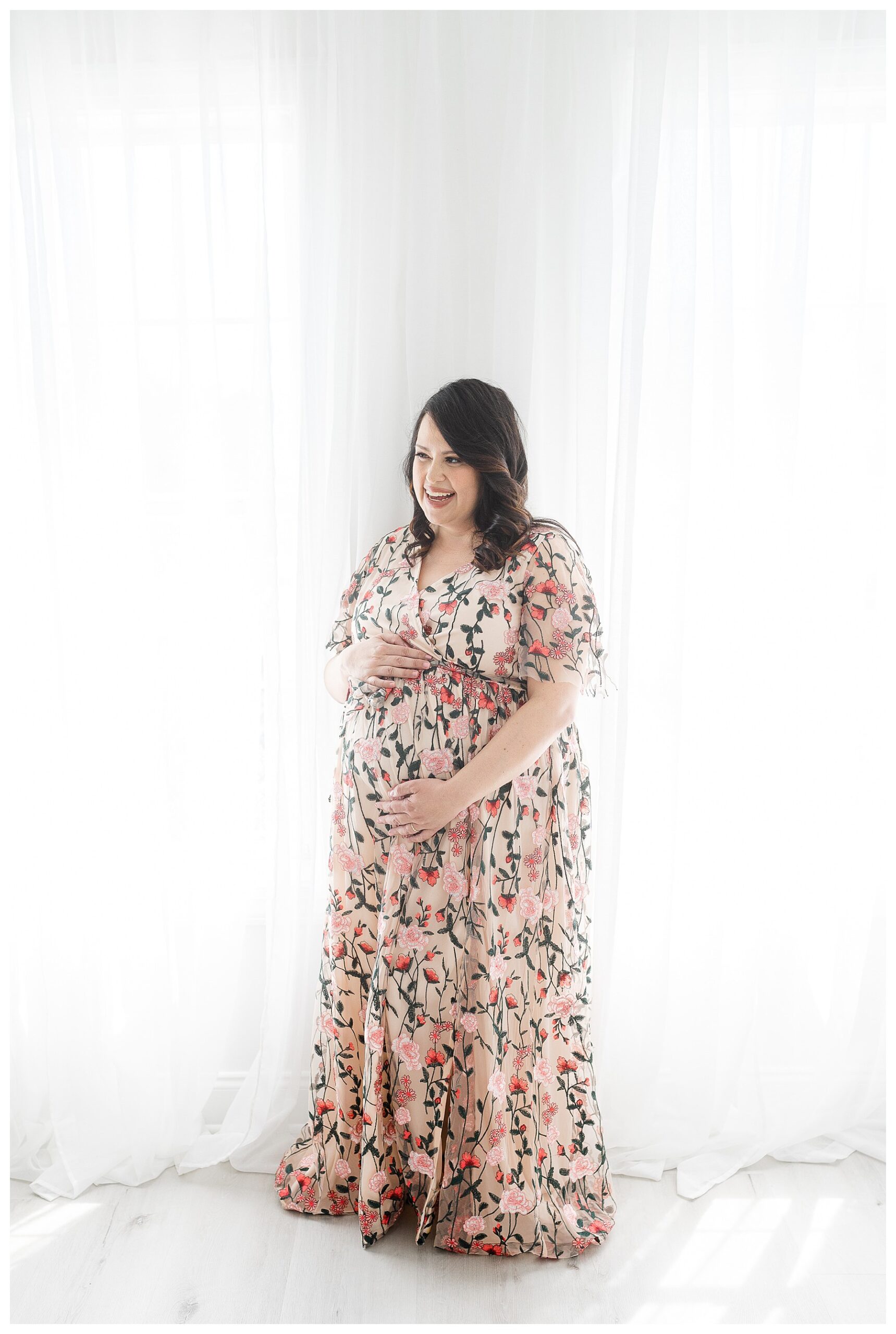 Pregnant mother cradling her belly for maternity photos.