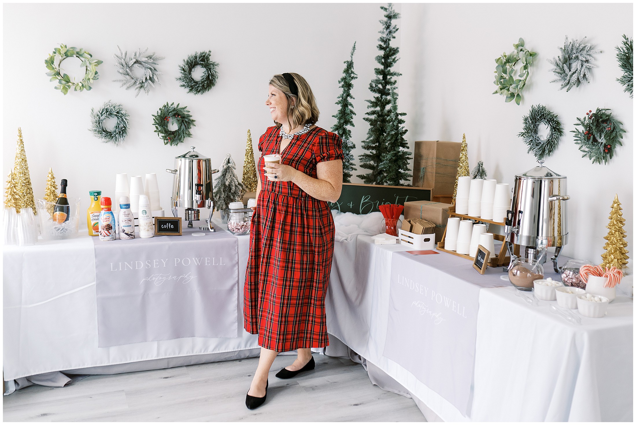 Photographer Lindsey Powell standing in front of a holiday spread during her Marietta Santa Photo Experience.