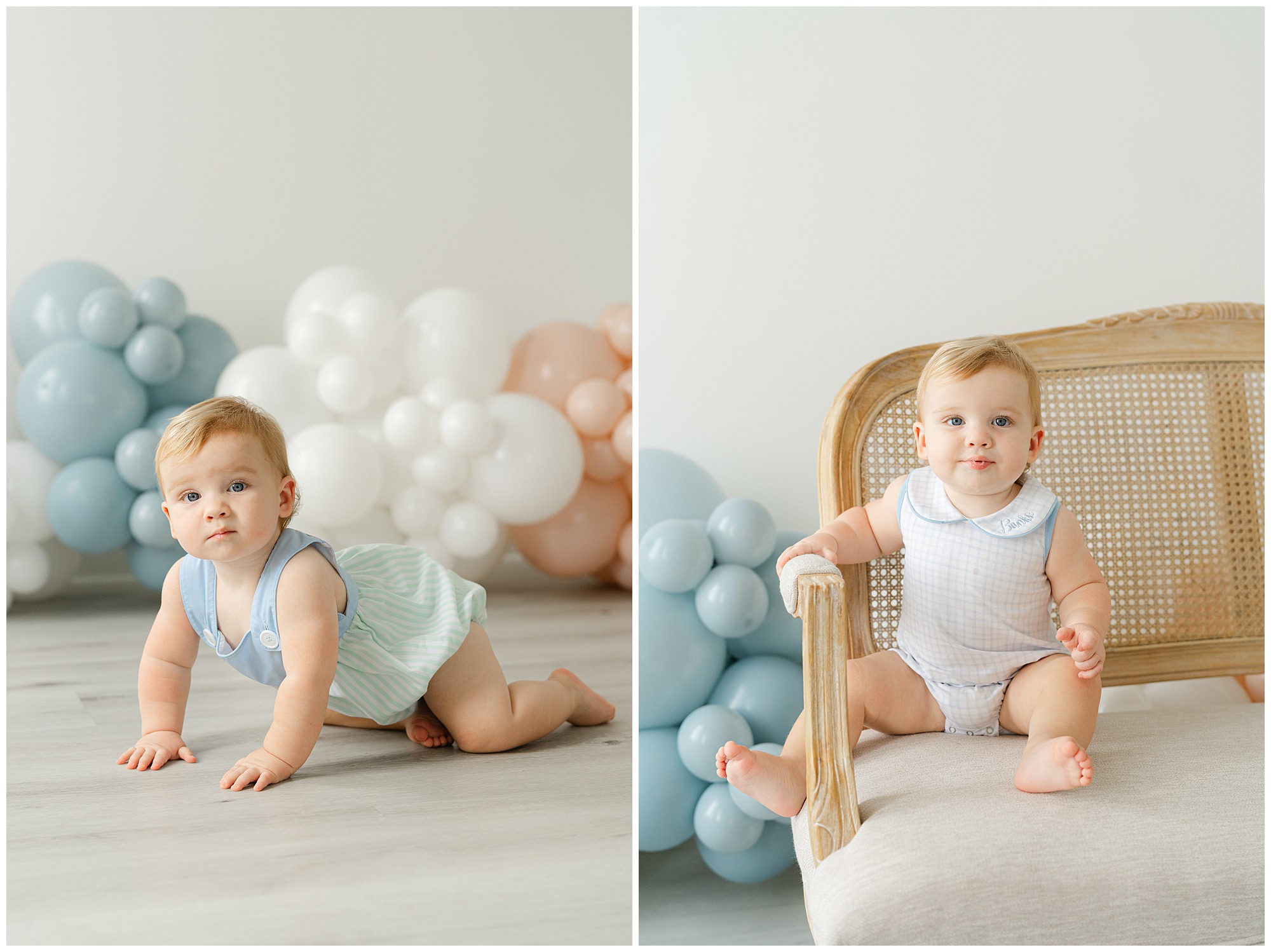 A one year old boy smiling for portraits in front of a blue, white, and pink balloon garland during her Atlanta Cake Smash session for twins